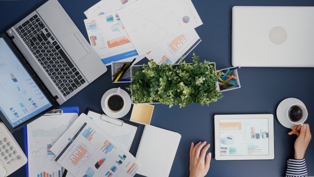 top-view-of-businesswoman-analyzing-financial-graphs-statistics-drinking-coffee-scaled.jpg